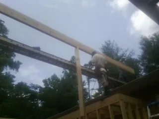 Carpenter setting a ridge beam over a new addition frame — Ice Dam Removal by Roofing Brothers in Apulia Station