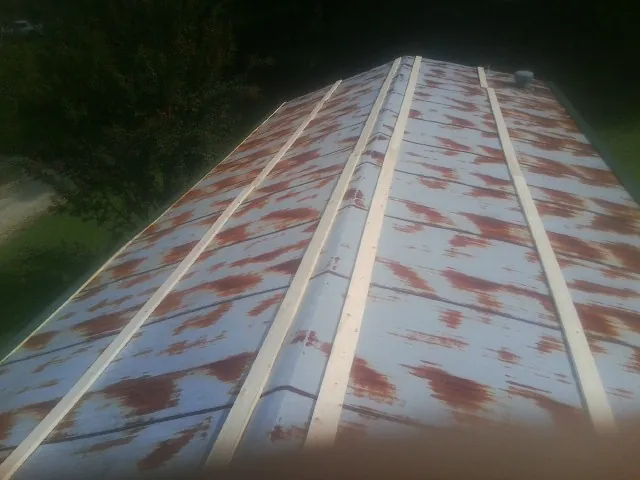 Rusted metal roof panels with new wood purlins before replacement — Storm Damage Roof Repair in Apulia Station by Roofing Brothers